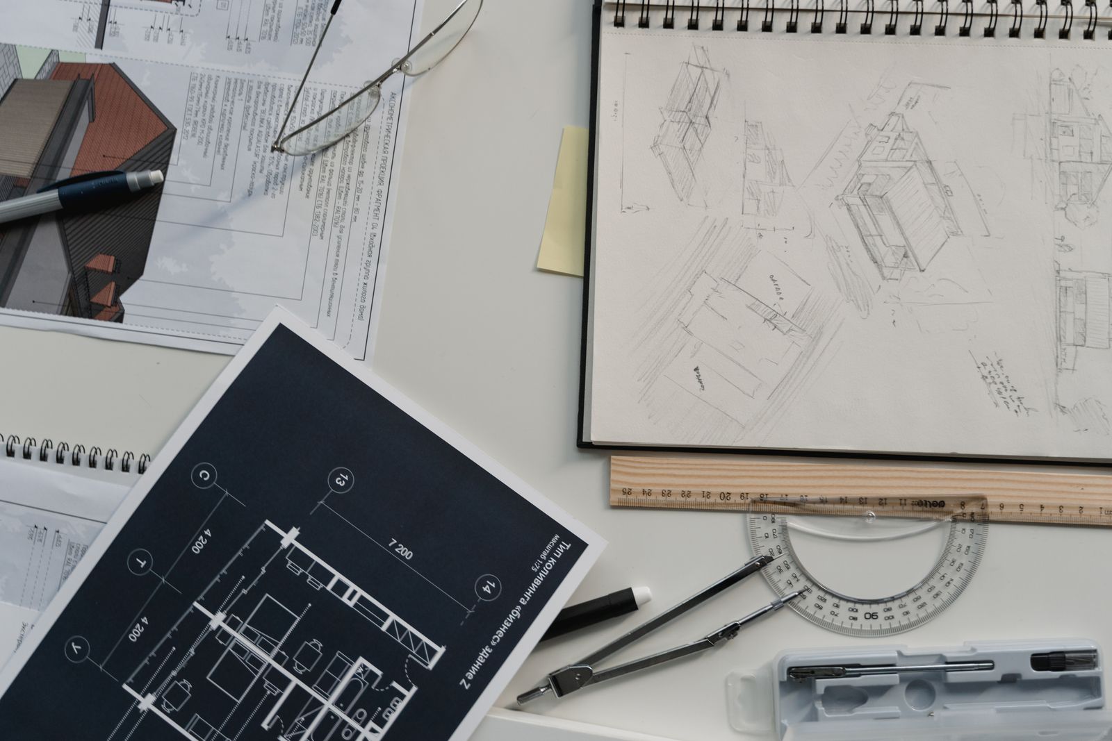 Bàn làm việc kiến trúc với bản vẽ, phác thảo và dụng cụ thiết kế
